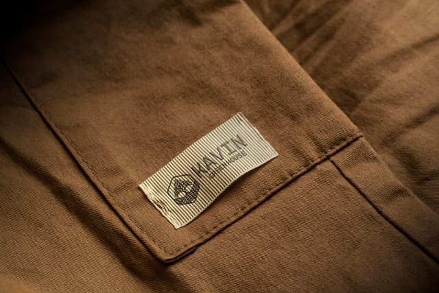 Woven brand tag applied to heavy-duty utility workwear.