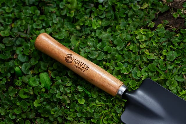 Laser-engraved logo on a wooden garden trowel handle.