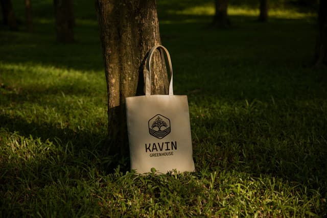 Screen-printed canvas tote bag photographed in a natural forest setting.